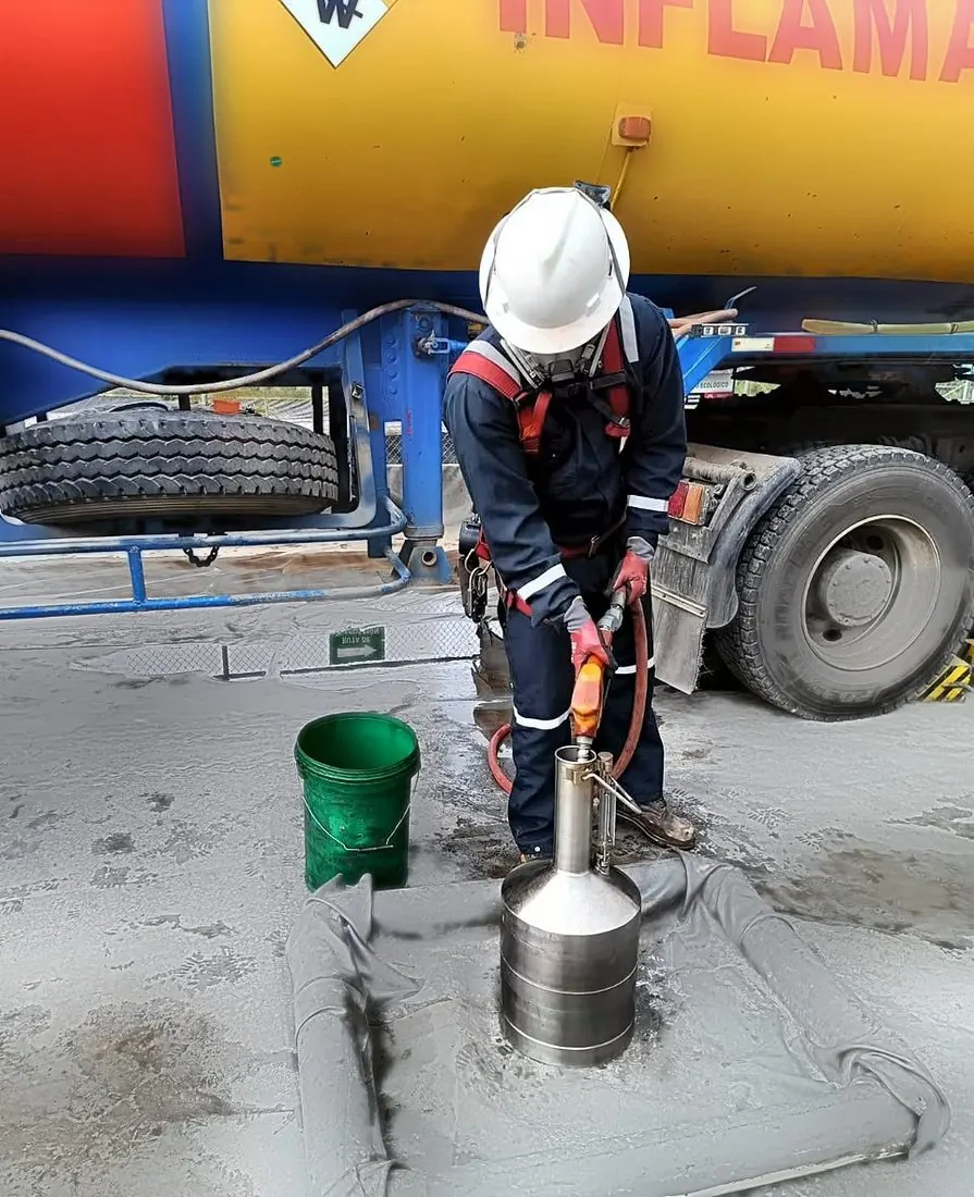 Operador de Tecknologistic tomando muestra de combustible sobre contención